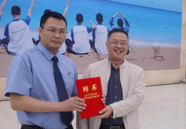 龍校長為胡檢察長頒發(fā)聘書