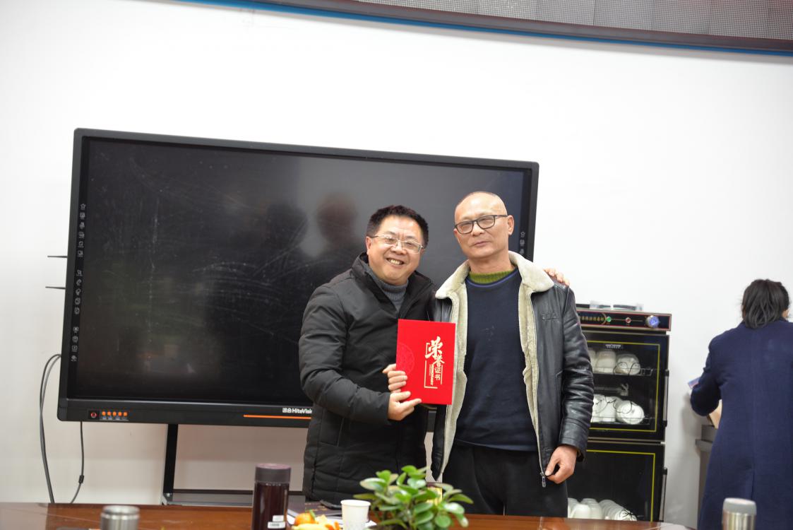 龍清明校長給退休教師吳銳頒發(fā)榮譽(yù)證書