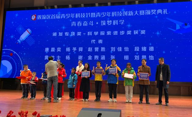 張栩同學(xué)（右四）代表小組領(lǐng)取科學(xué)探索進步獎 